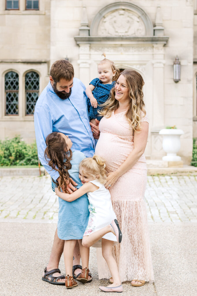 Mom and Dad laughing and hugging their children during a maternity session in Pittsburgh, PA