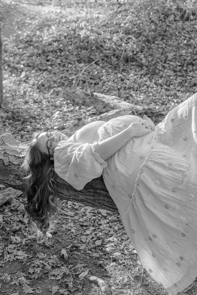 Beautiful mama to be laying on a branch in an outdoor session in Pittsburgh, PA Maternity Photography Session