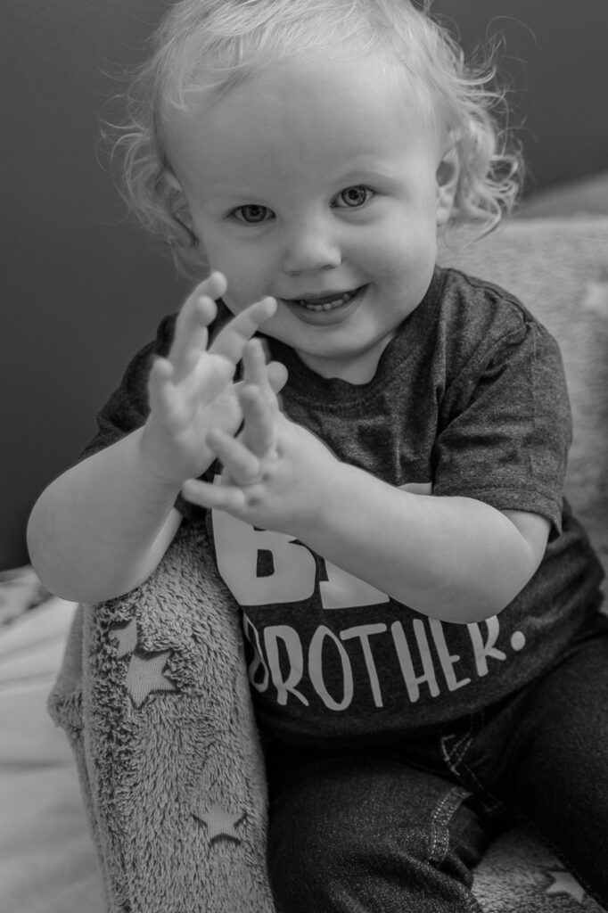Proud big brother posing during a lifestyle newborn session that was located in Pittsburgh, PA