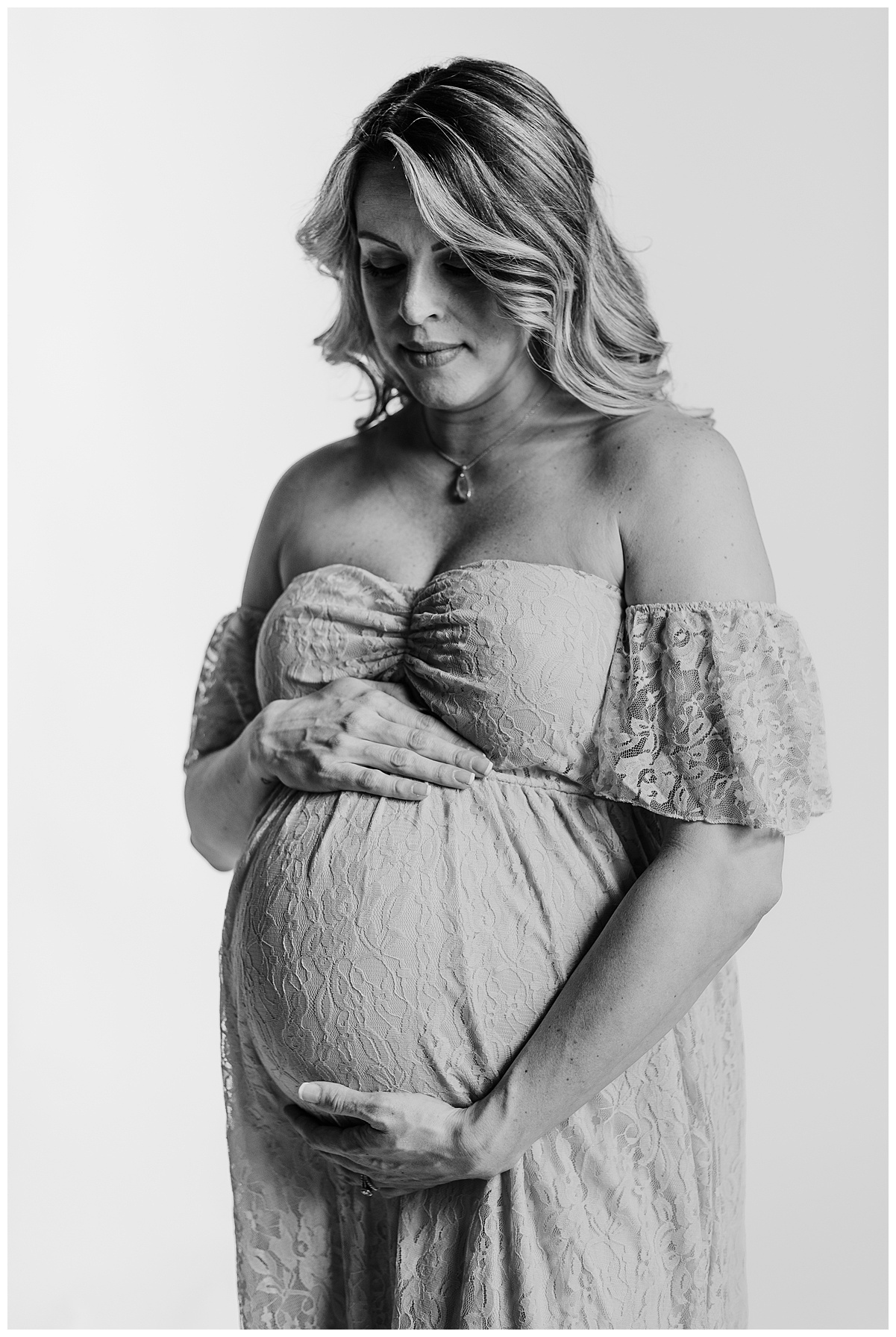 Beautiful mama to be posing for her last pregnancy maternity photoshoot.  The picture is in black and white and the mom is looking at her belly.   taken by a maternity photographer in Pittsburgh, pa