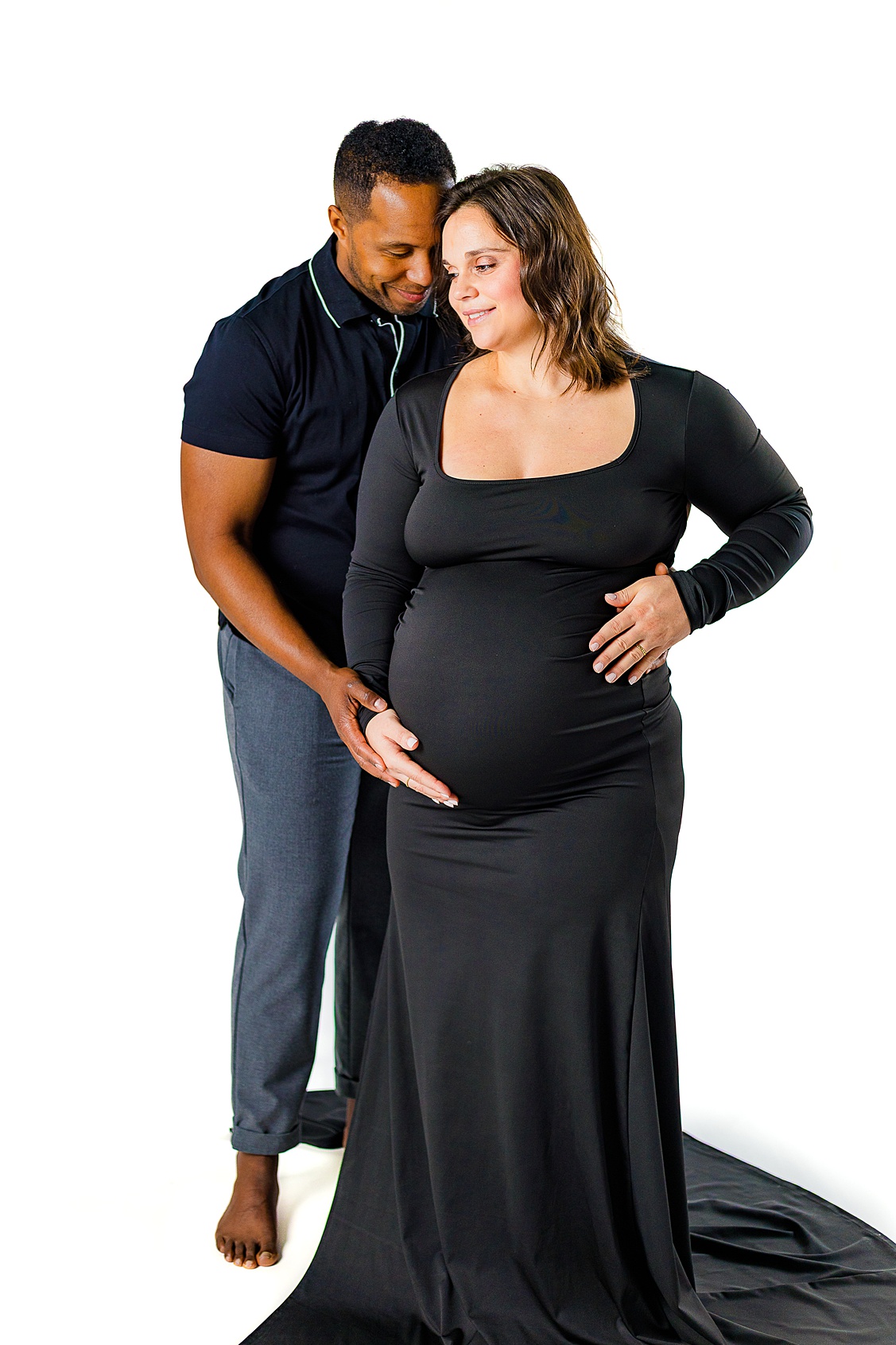 This sweet couple standing close together and both holding the baby bump. This is an indoor studio maternity session in Pittsburgh, PA