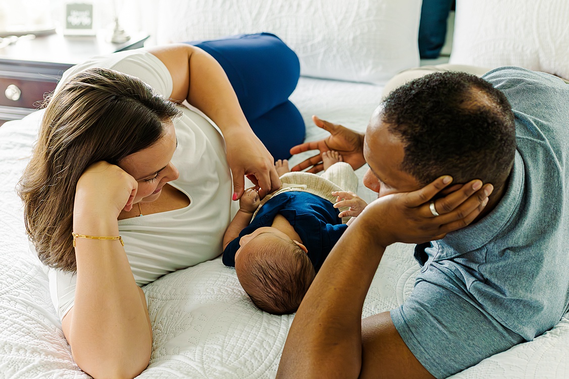 Mom and Dad are on the bed with their baby boy in between them. This was taken during an in home session with a wexford baby photographer