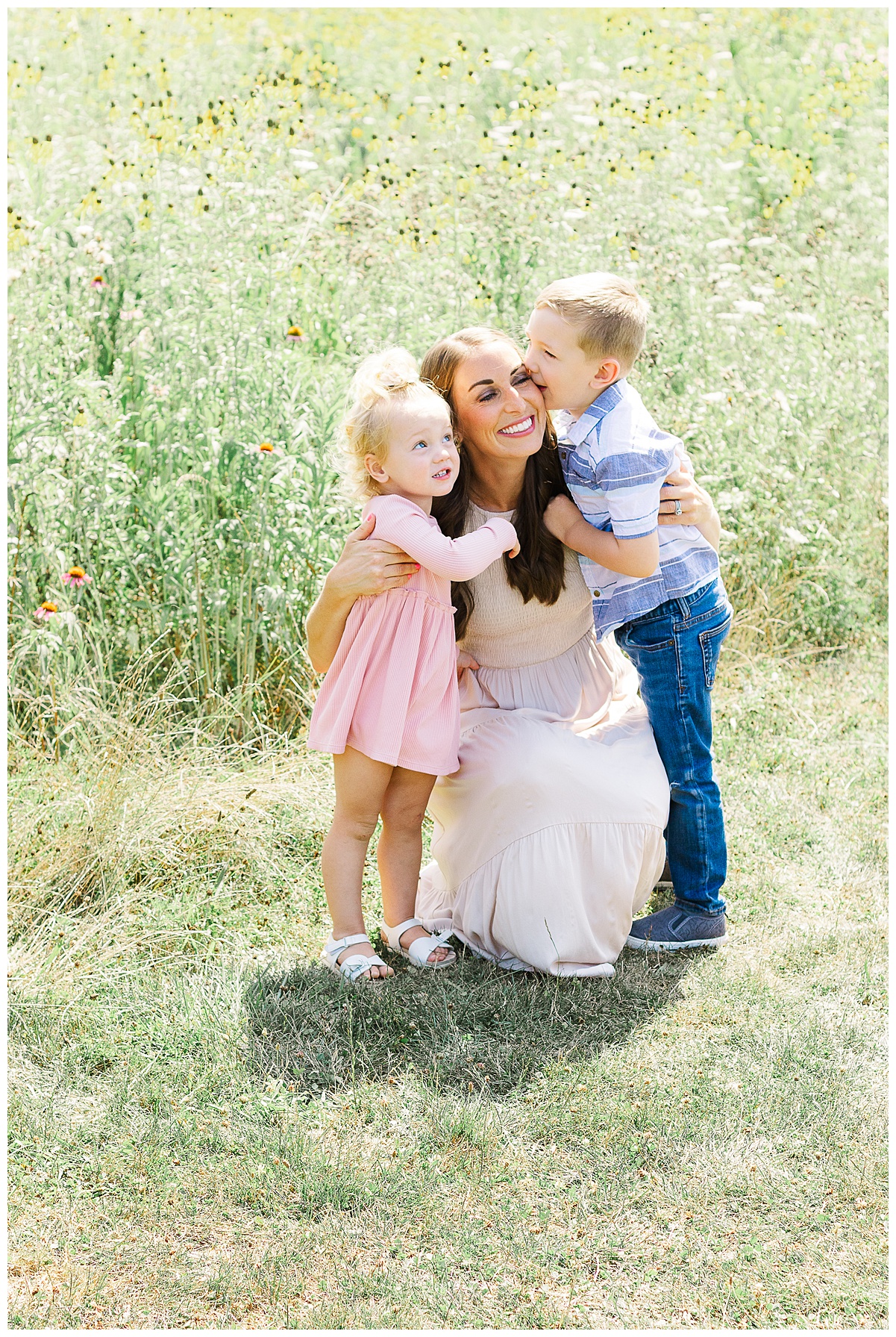 Mom is sitting with her kids and both are hugging her. Taken during a family outdoor session in Pittsburgh, PA.