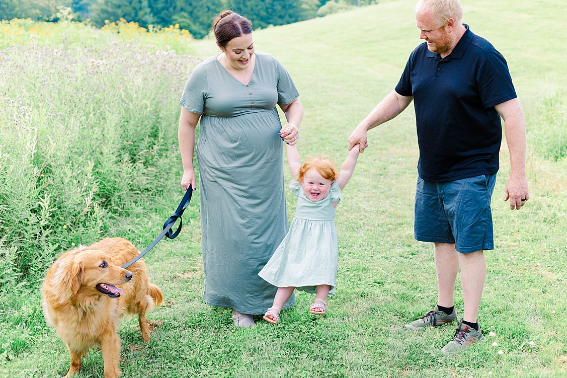 Mom and dad walking with their toddler and their family dog during a maternity photoshoot in Pittsburgh