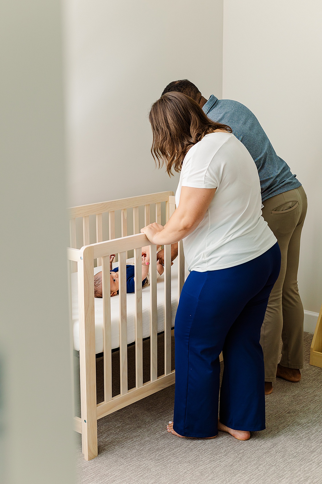 Mom and Dad looking in on their son while he is in the crib. Captured by Shayna VanDamia Photography who is a Wexford Baby Photographer.