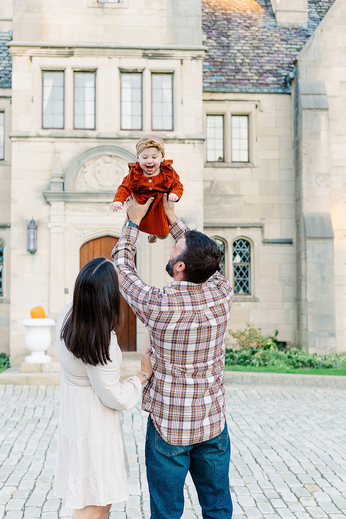 mom and dad tossing their daughter up in the air.  someday she will look at these pictures and know how much fun it was during her family session in wexford
