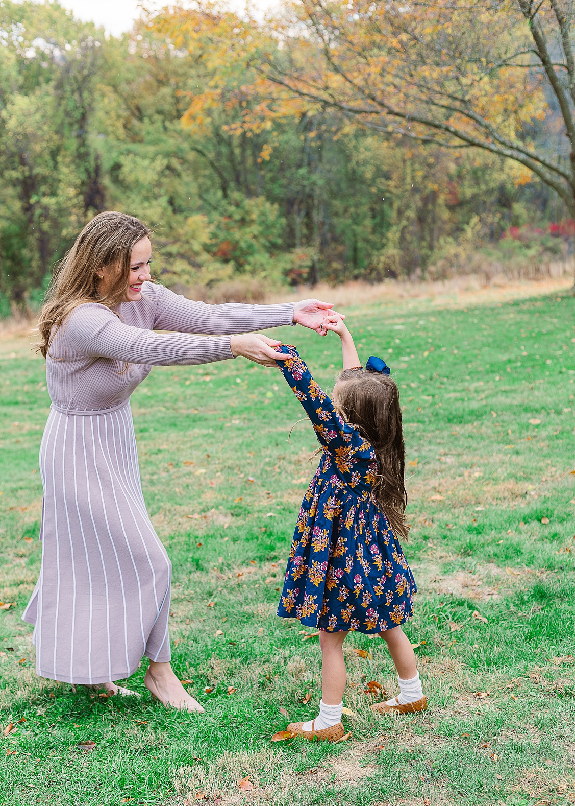 Mom and daughter twirling around and dancing during their outdoor family session in Pittsburgh.