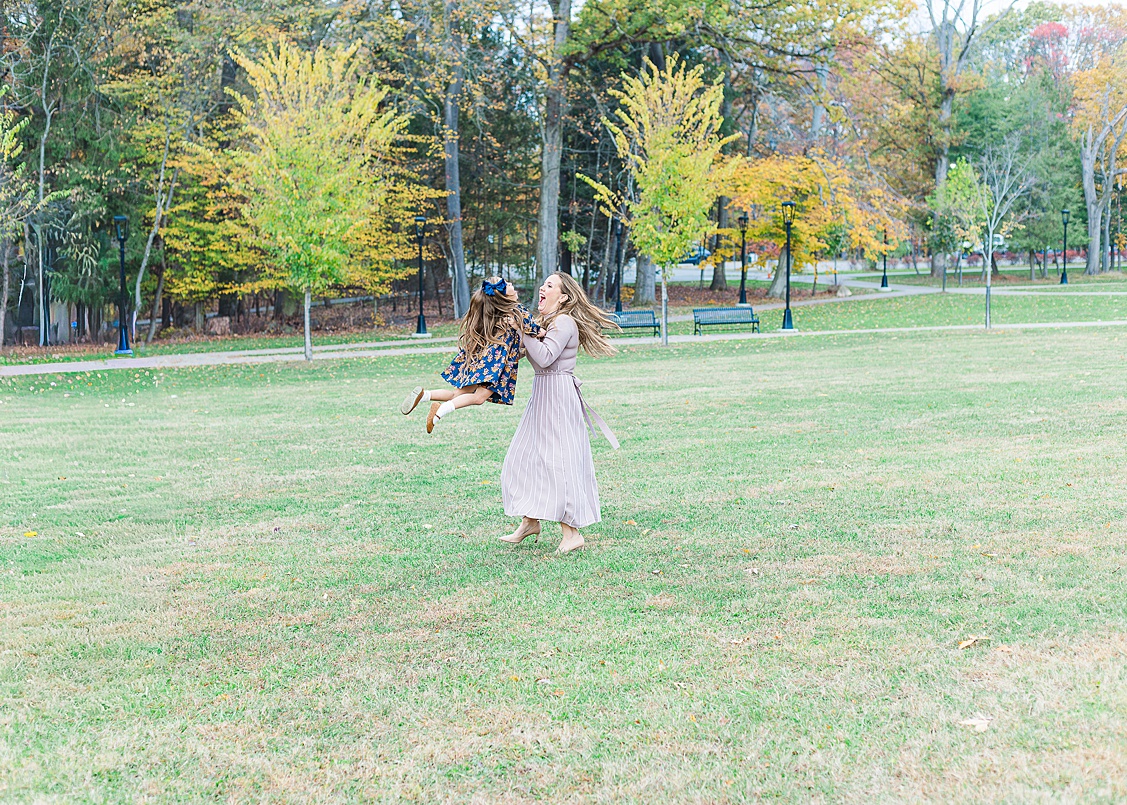 Mother holding her daughter with a beautiful landscape in the background during a family session.
