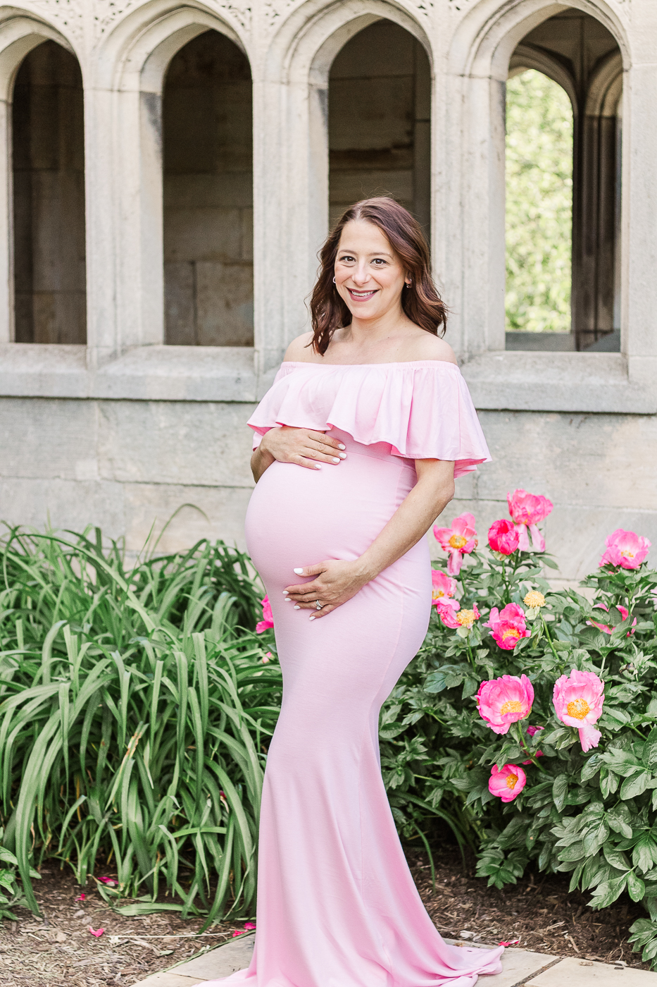A local maternity photographer in Pittsburgh took this picture of this beautiful mama to be surrounded by flowers while wearing a pink dress. 