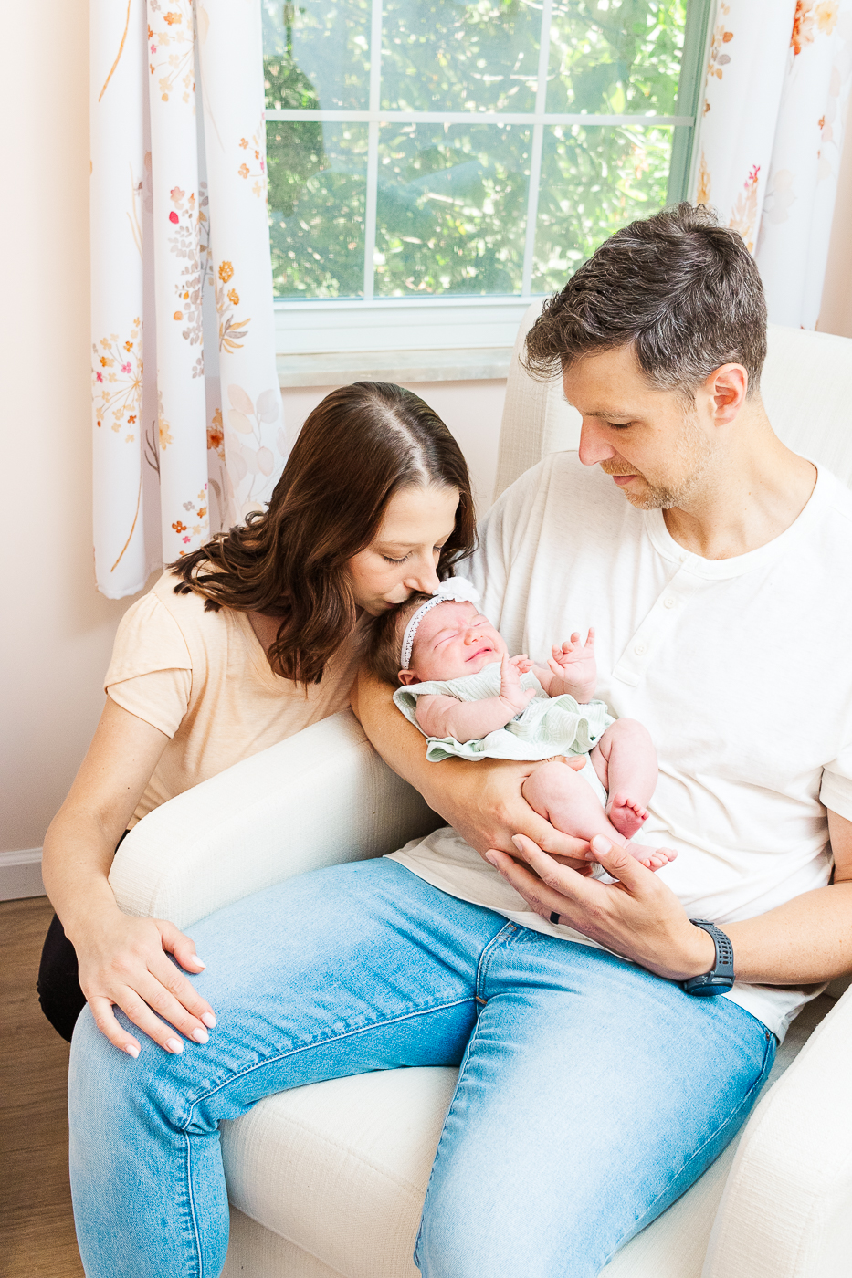In-home newborn photographer in Pittsburgh captured parents in the nursery and mom is kissing baby's head