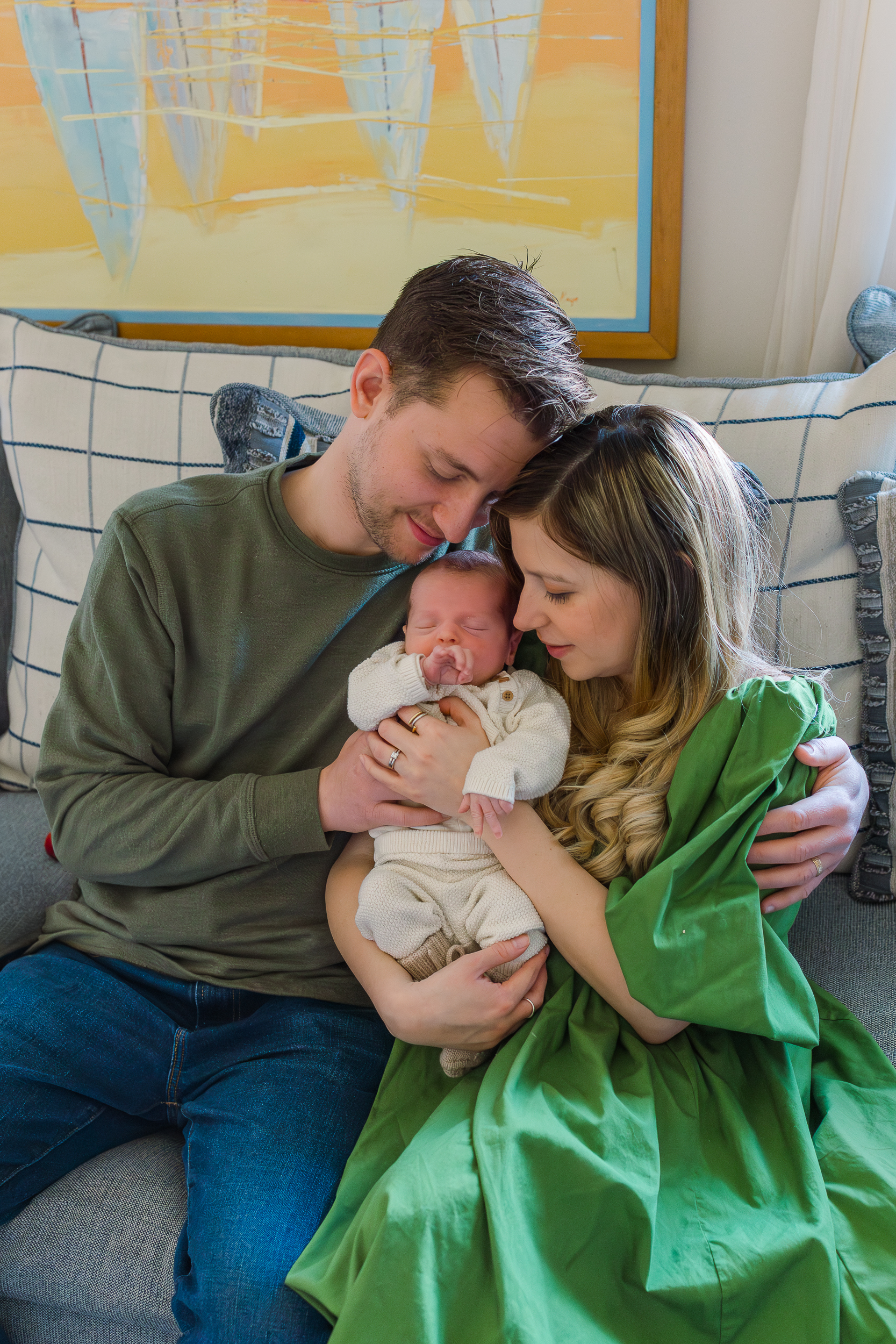 Sweet moment between mom, dad and baby.  Both are holding baby while looking at him with lots of love.  This was taken by a Wexford, PA Newborn Photographer.