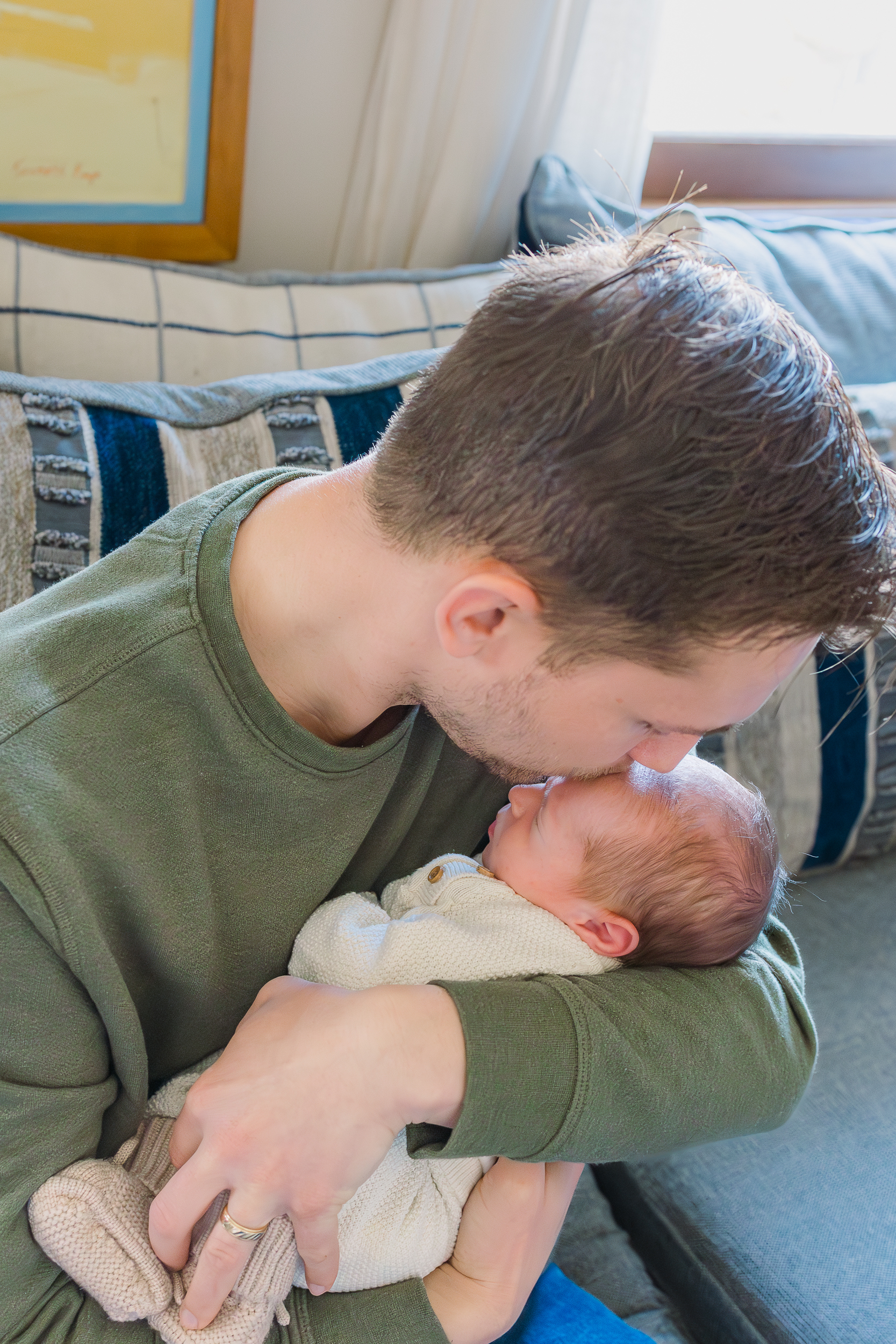 Dad is kissing his baby boy on the head during their in home Wexford, pa Newborn Session