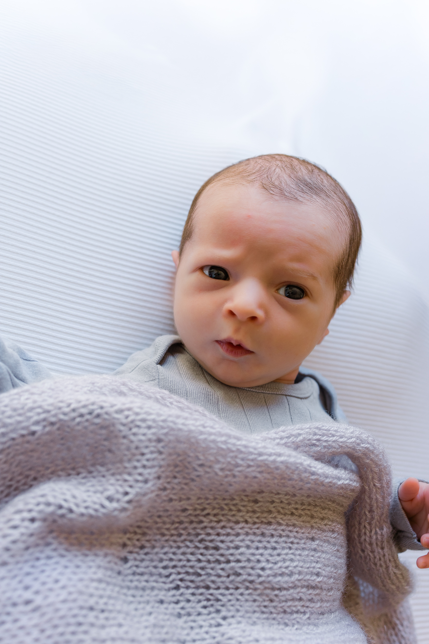 Baby boy looking and making a face during his newborn session in Wexford, PA.