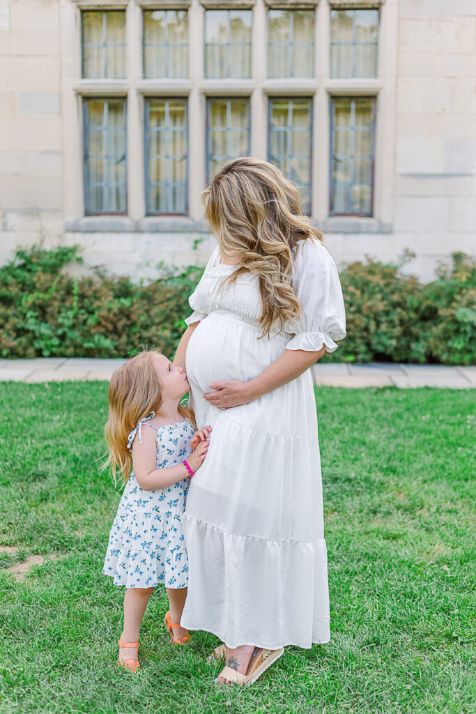 Little girl kissing moms baby belly during the moms maternity photography session in Pittsburgh.