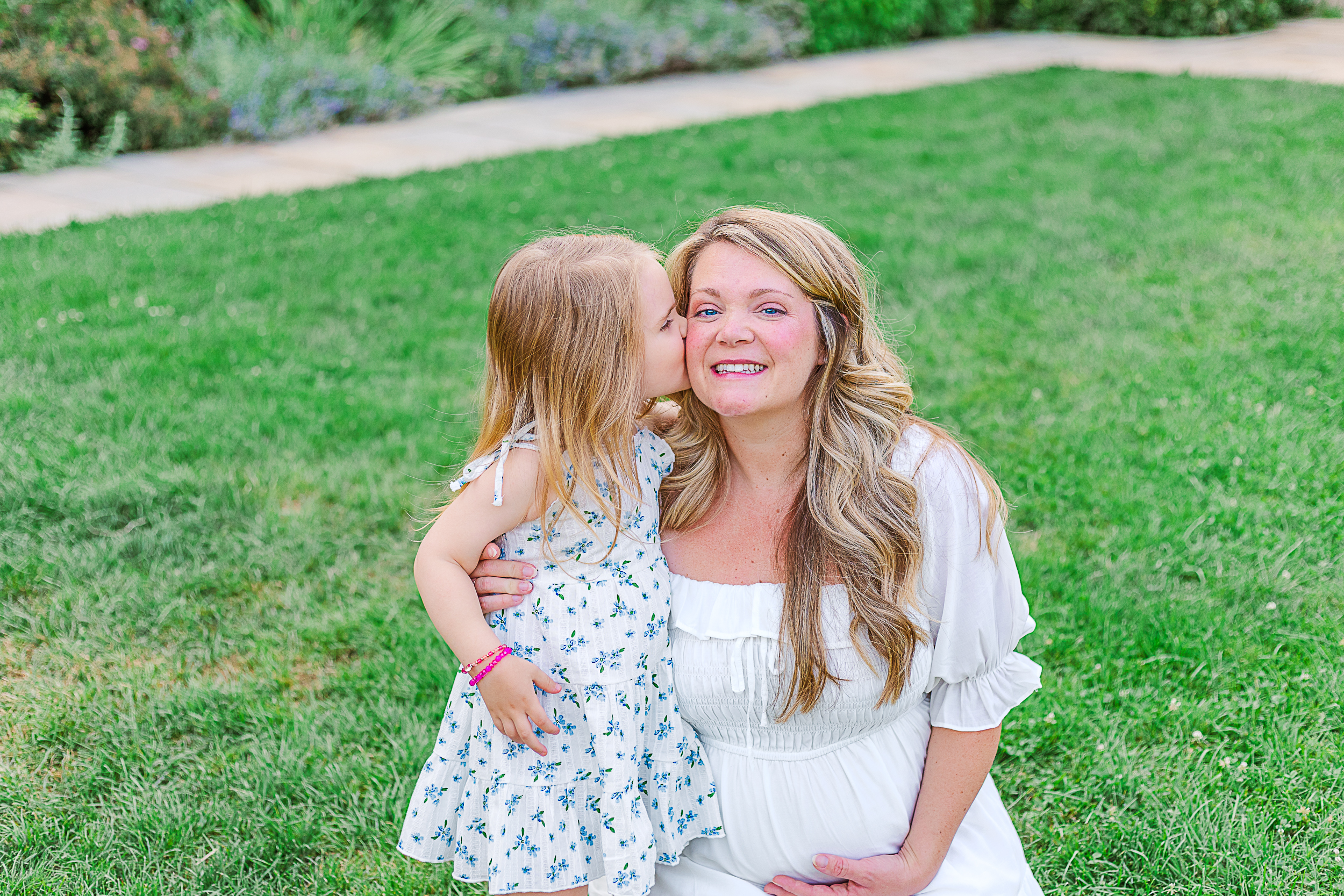 Little girl is kissing moms cheek during her maternity session in Pittsburgh. 