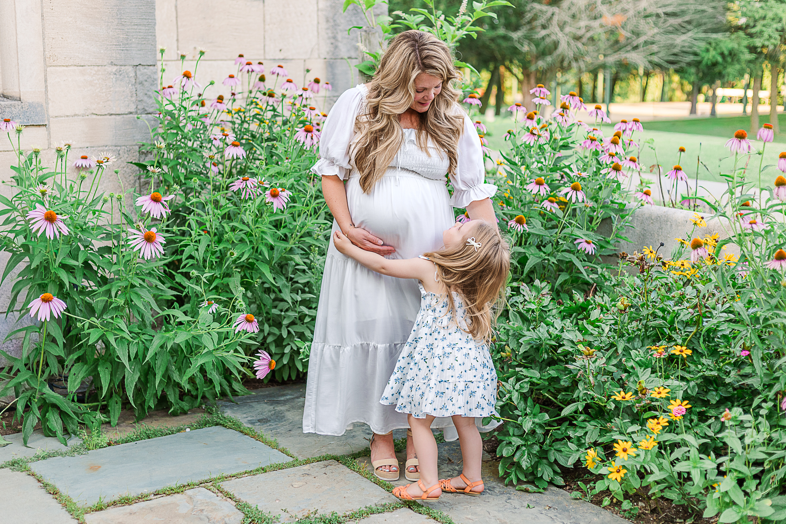Little girl is hugging mom and her belly during her maternity photography session in Pittsburgh. 