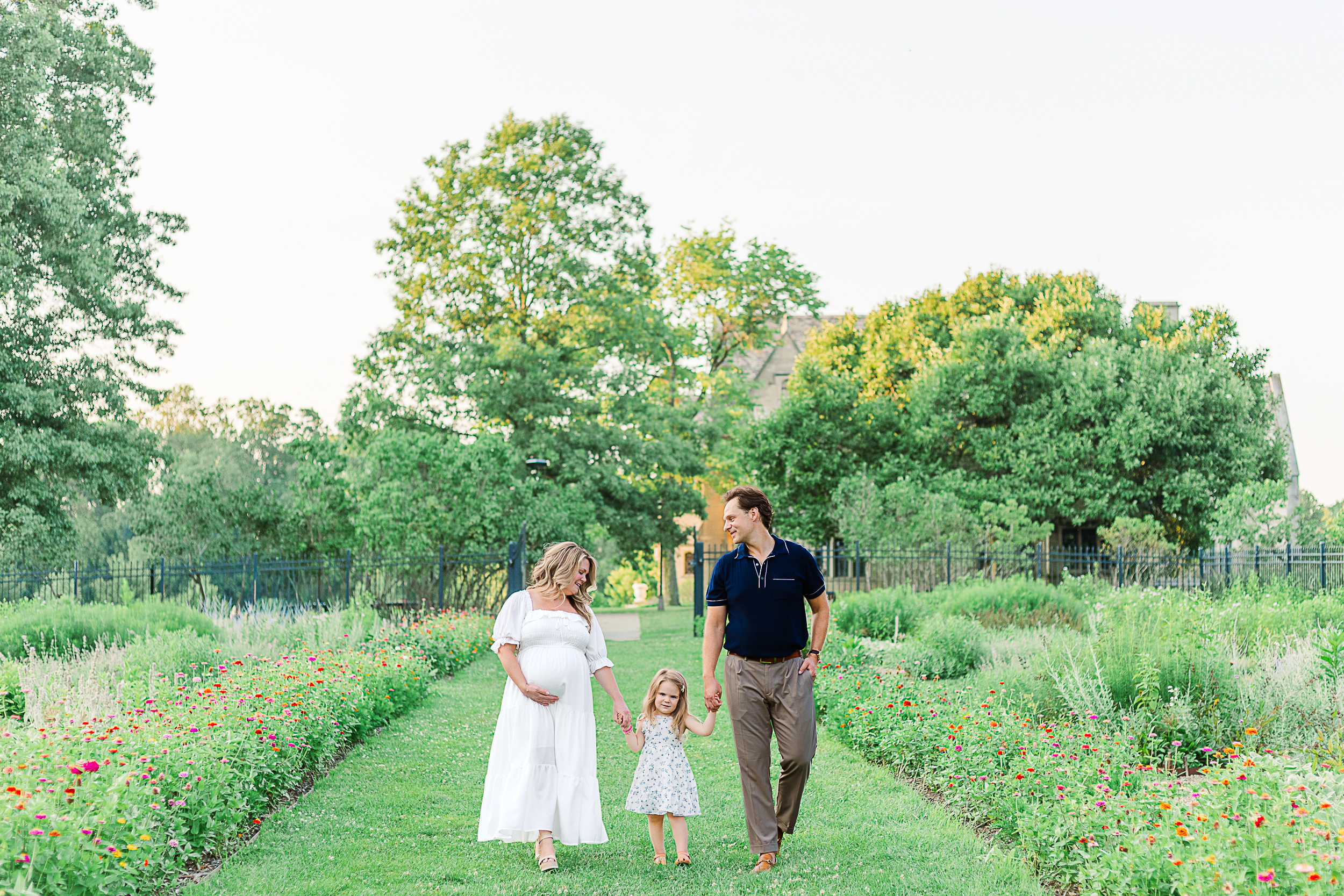 Mom and dad and little girl are walking enjoying being a family of 3 before baby brother is born.  Taken in Pittsburgh at Hartwood Acres Mansion.