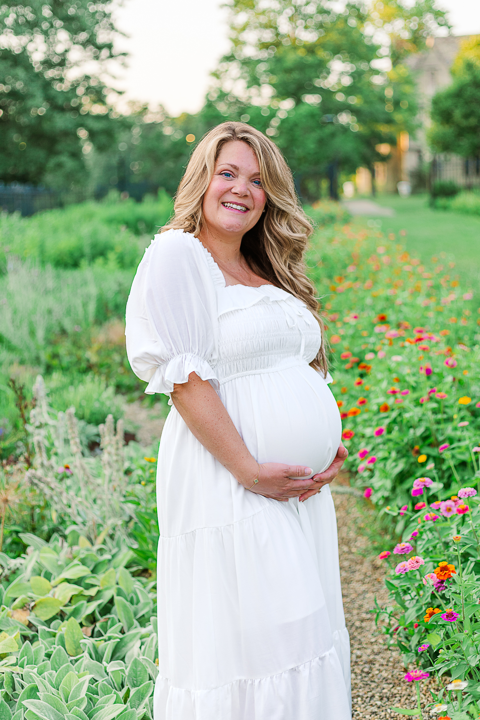 Beautiful mom to be surrounded by flowers at Hartwood Acres Mansion flower garden in Pittsburgh, PA.